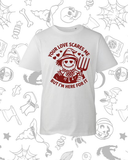 White t-shirt featuring a red graphic of a smiling scarecrow holding a pitchfork with the text "Your Love Scares Me But I'm.