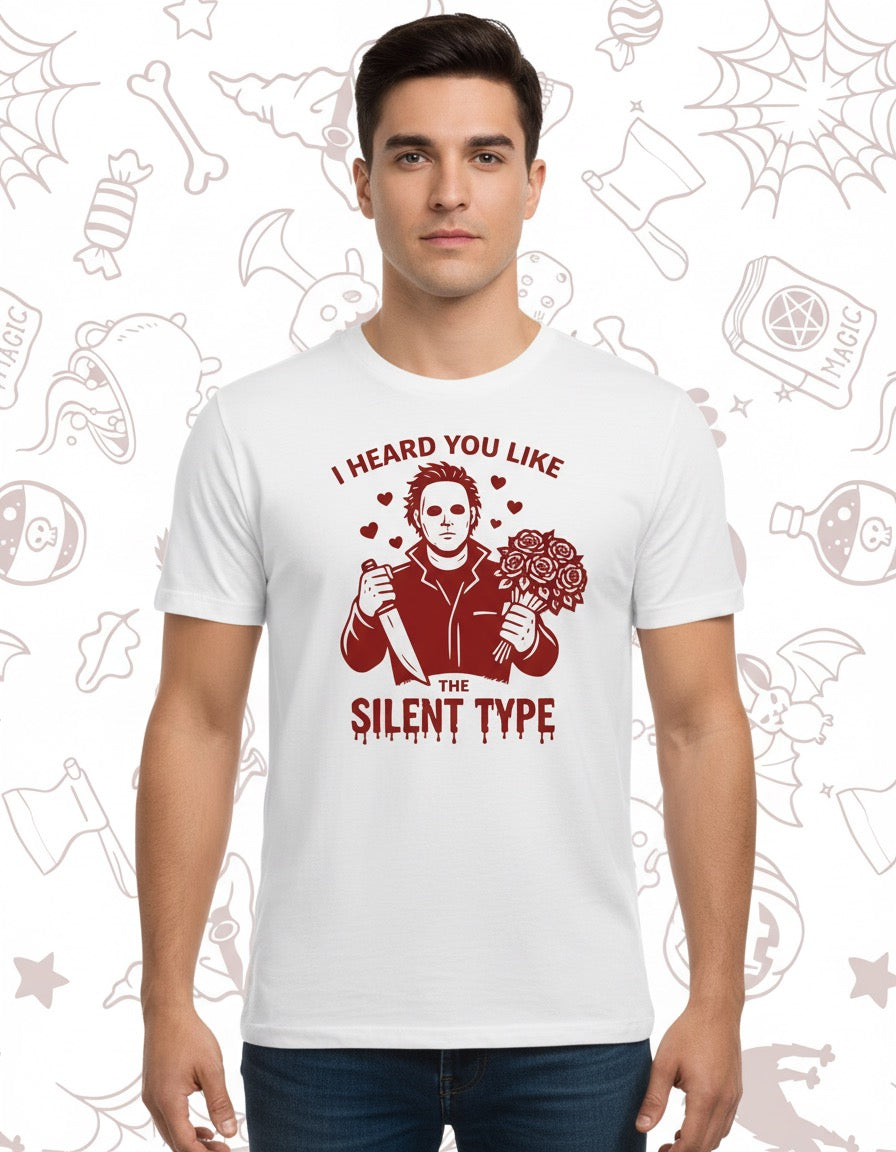 White cotton t-shirt featuring a maroon graphic of Michael Myers holding a knife and a pumpkin with the text "I heard you.