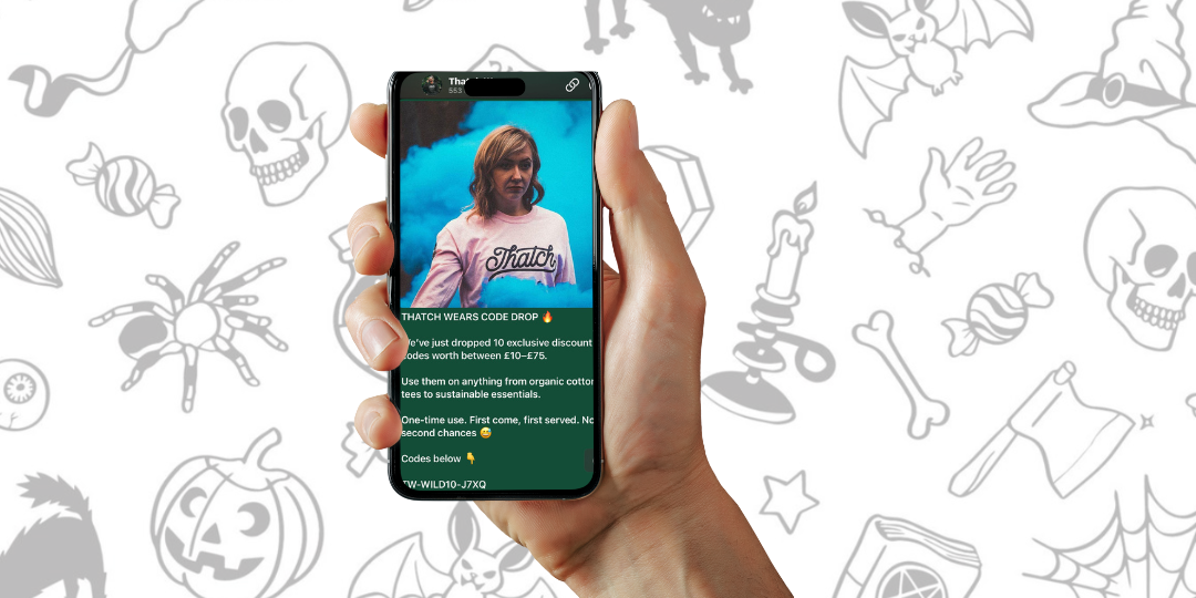 Hand holding a smartphone displaying a streaming app with a Halloween-themed background