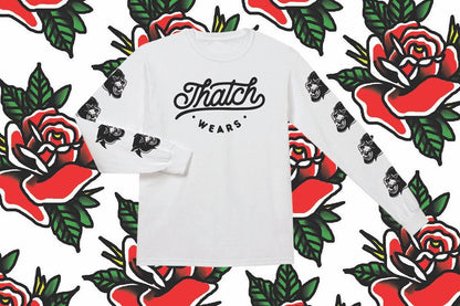 White long-sleeve organic cotton tee with black "Thatch Wears" logo on the front and black panther head prints down both.